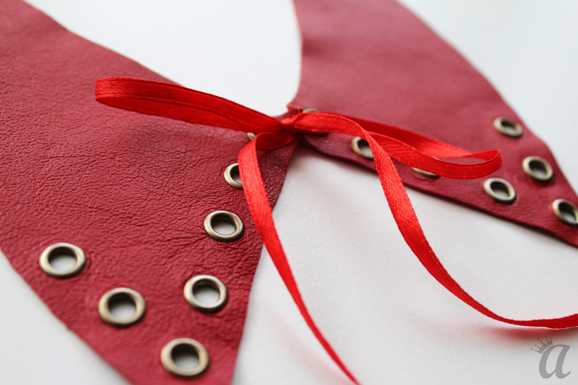red leather necklace with bow and metallic application (detail)